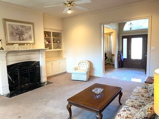 carpeted living room featuring ornamental molding, a fireplace, and ceiling fan