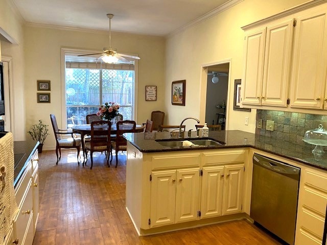 kitchen featuring dishwasher, ornamental molding, wood finished floors, a peninsula, and a sink