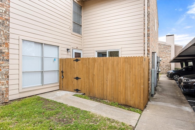 view of property exterior featuring brick siding and fence