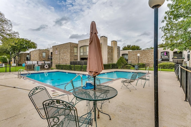 community pool with fence and a patio