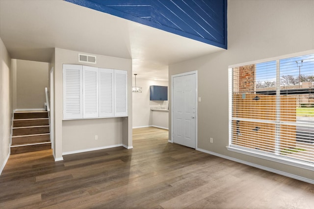 interior space featuring stairway, wood finished floors, visible vents, and baseboards