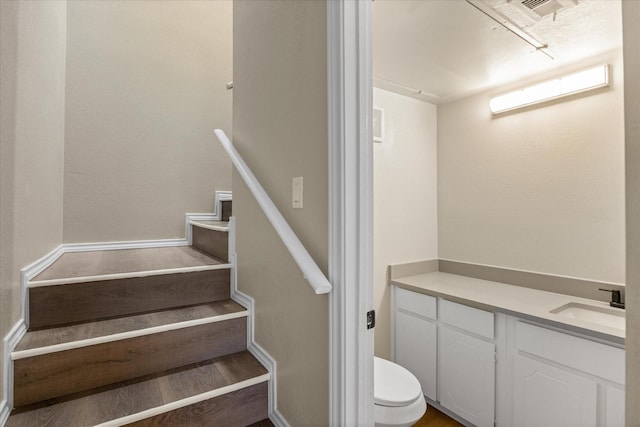 stairs with visible vents and wood finished floors