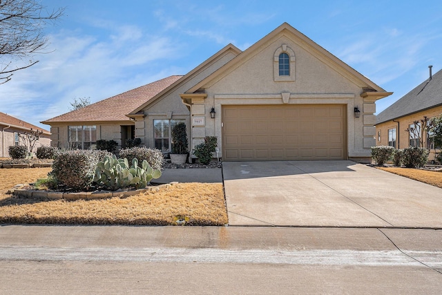 view of front of house with concrete driveway, an attached garage, and stucco siding