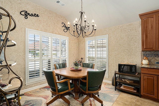 dining room featuring a chandelier, visible vents, vaulted ceiling, and baseboards