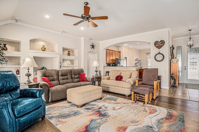 living area featuring a healthy amount of sunlight, built in features, arched walkways, and hardwood / wood-style floors