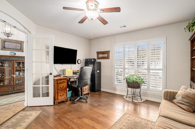 office space with wood-type flooring, visible vents, ceiling fan, and a healthy amount of sunlight