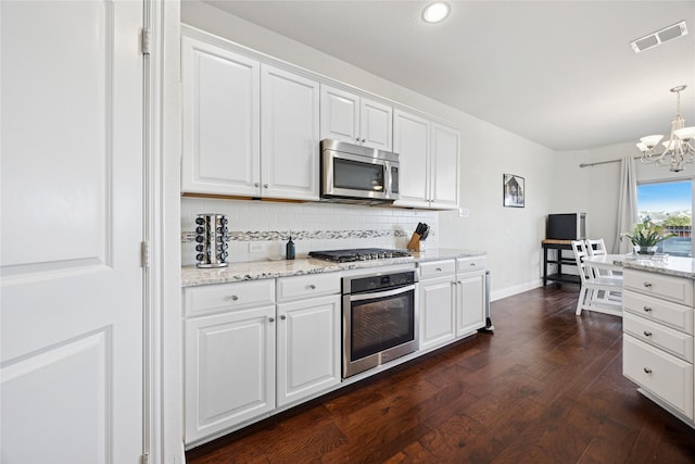 kitchen featuring stainless steel appliances, dark wood-style flooring, white cabinets, and decorative backsplash