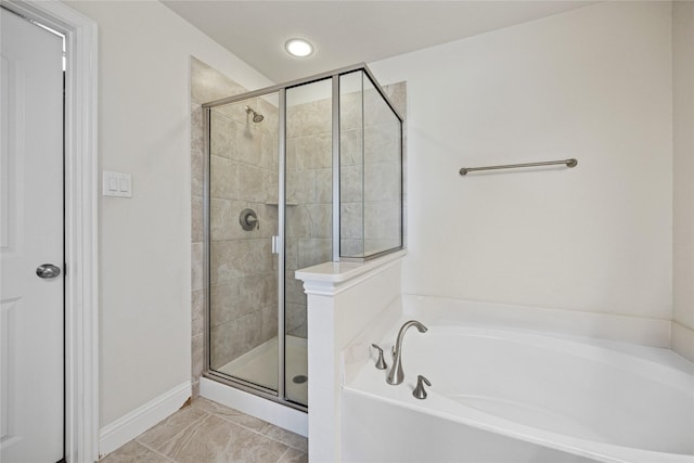 bathroom with a stall shower and a garden tub