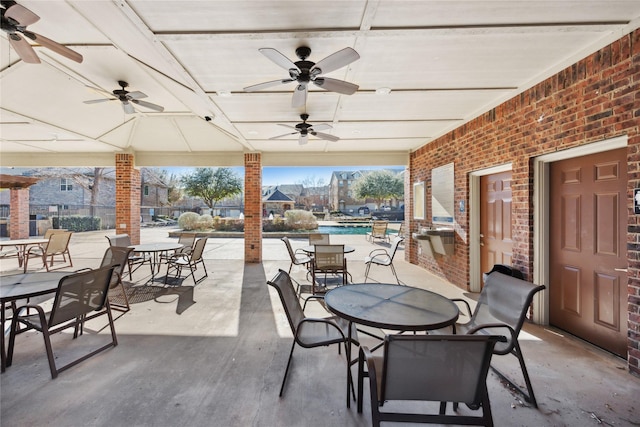 view of patio / terrace featuring outdoor dining space, ceiling fan, and a community pool