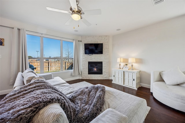 bedroom featuring a brick fireplace, baseboards, visible vents, and wood finished floors