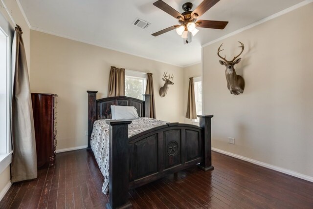 bedroom with baseboards, crown molding, visible vents, and dark wood-type flooring