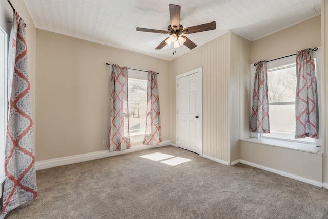 unfurnished bedroom with carpet, a ceiling fan, and baseboards