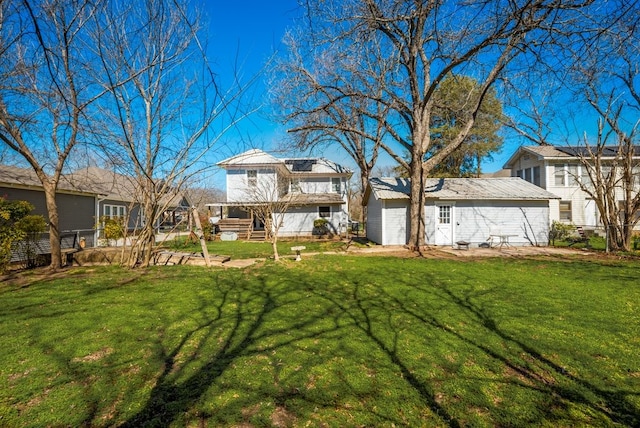 rear view of property featuring fence, metal roof, and a yard