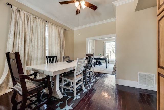 dining area with ceiling fan, visible vents, baseboards, ornamental molding, and dark wood-style floors