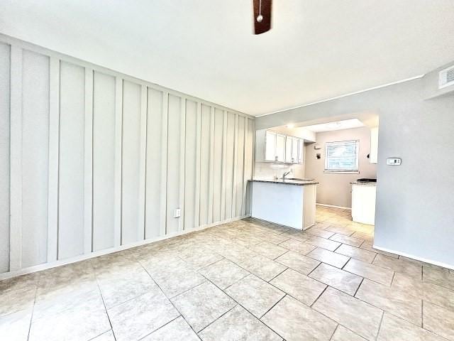 unfurnished living room with a sink and light tile patterned floors