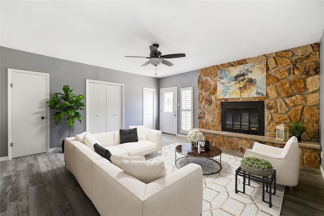 living room featuring a fireplace, wood finished floors, and a ceiling fan