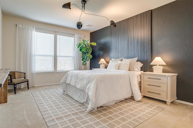 bedroom featuring baseboards, visible vents, and light colored carpet