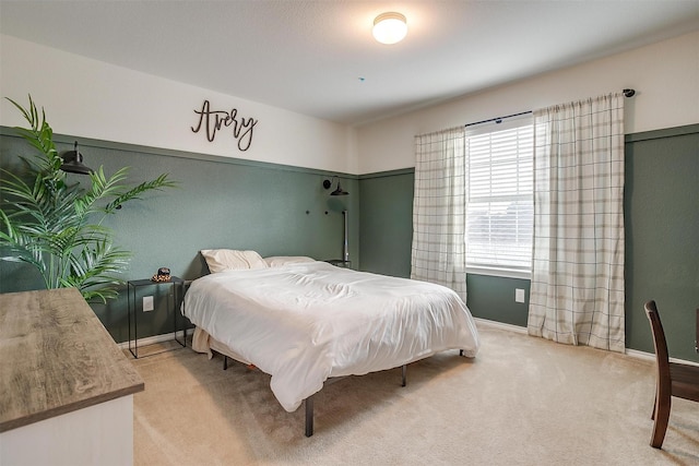 bedroom with baseboards and light colored carpet