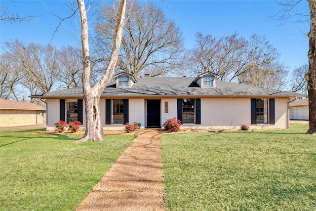 view of front of property featuring a shingled roof, a front lawn, and brick siding