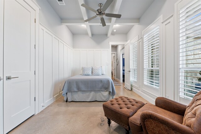 bedroom featuring visible vents, coffered ceiling, beamed ceiling, finished concrete floors, and a decorative wall