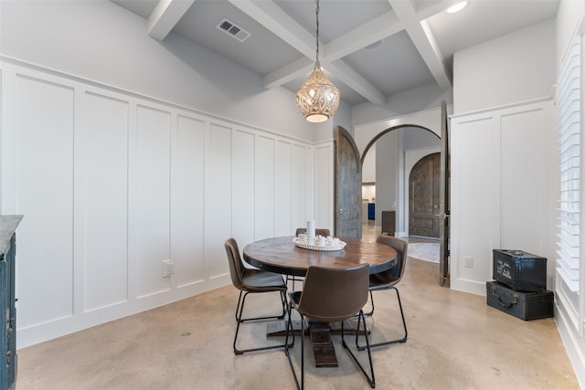 dining room featuring arched walkways, beamed ceiling, visible vents, and a decorative wall