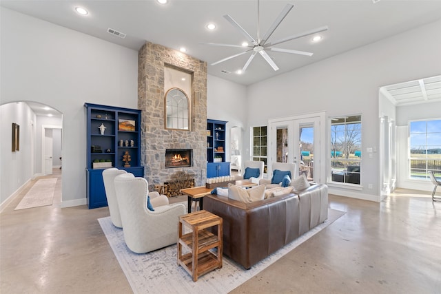 living area featuring visible vents, a high ceiling, arched walkways, and concrete flooring