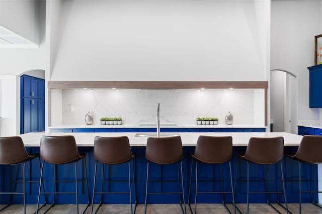 kitchen with blue cabinets, light countertops, and decorative backsplash