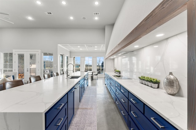 kitchen with black electric stovetop, recessed lighting, blue cabinets, a sink, and visible vents