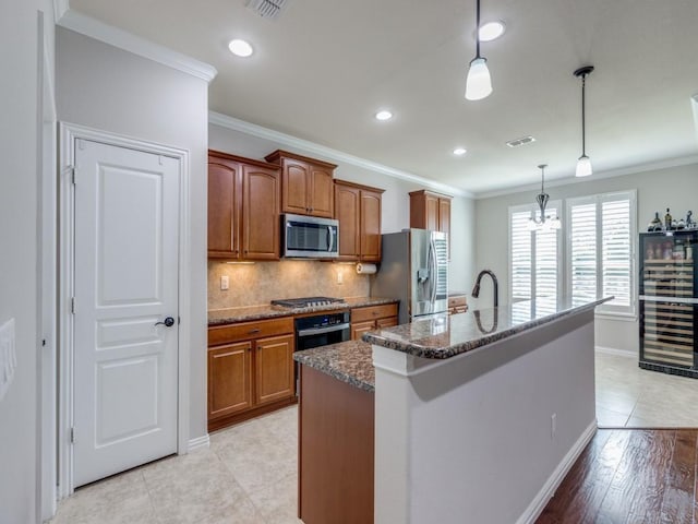 kitchen with appliances with stainless steel finishes, brown cabinetry, visible vents, and crown molding