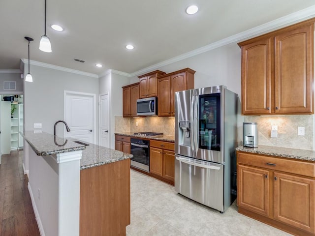 kitchen featuring stainless steel appliances, visible vents, a sink, and light stone countertops