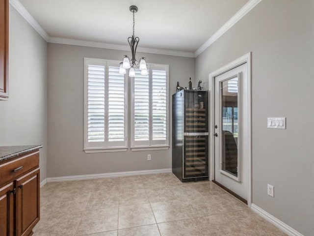 dining area featuring a chandelier, wine cooler, ornamental molding, and baseboards