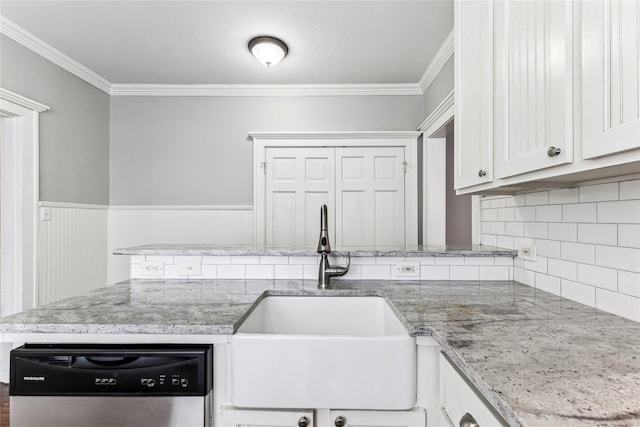 kitchen featuring dishwasher, crown molding, a sink, and a wainscoted wall