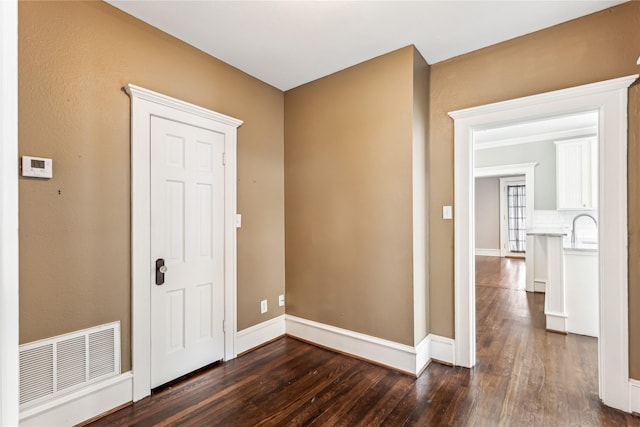 entrance foyer with dark wood-style floors, visible vents, and baseboards