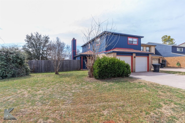 view of front facade with a garage, concrete driveway, fence, a front yard, and brick siding