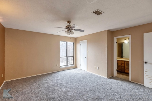 unfurnished bedroom with baseboards, carpet, visible vents, and a textured ceiling