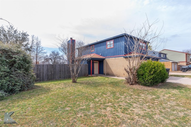 traditional-style house with a front yard, fence, and brick siding