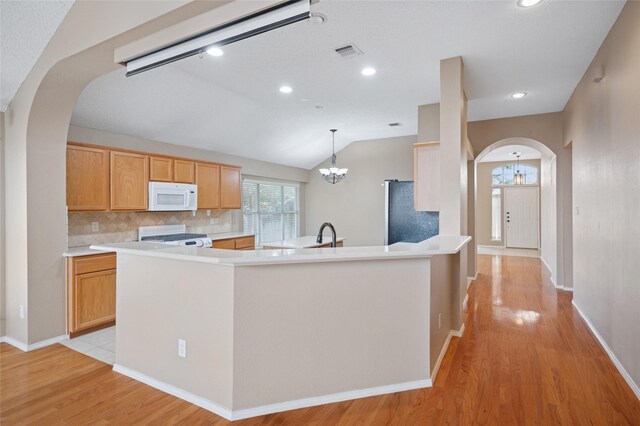 kitchen with visible vents, arched walkways, range, white microwave, and fridge