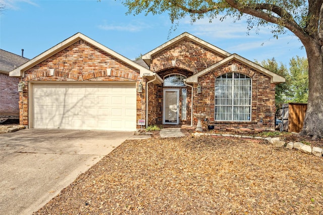 ranch-style house with a garage, concrete driveway, and brick siding