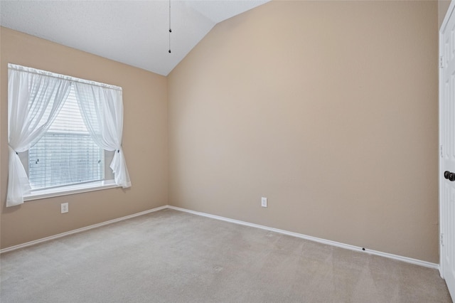 unfurnished room featuring vaulted ceiling, carpet, and baseboards