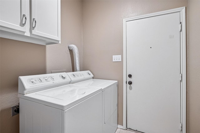 clothes washing area featuring cabinet space and independent washer and dryer