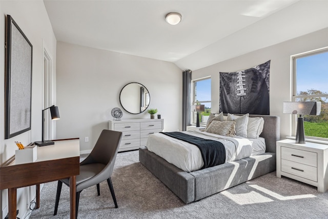 carpeted bedroom featuring lofted ceiling and multiple windows