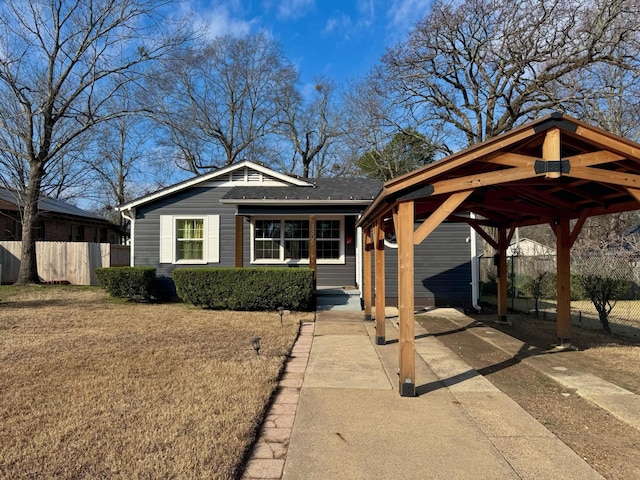 view of front of home with a front yard and fence