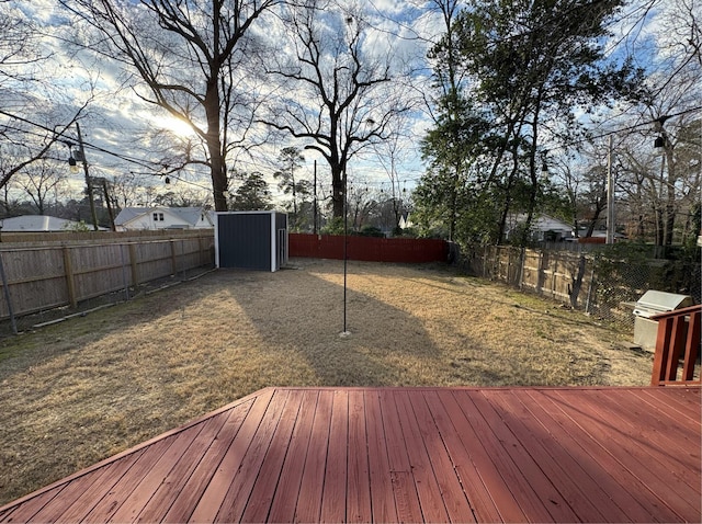 deck with an outbuilding, area for grilling, and a fenced backyard