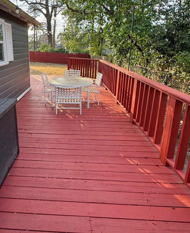 deck with outdoor dining space and fence