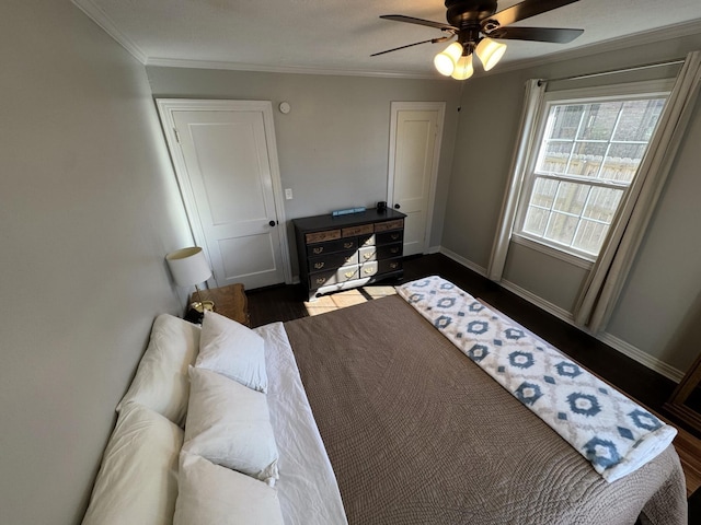 bedroom featuring baseboards, ornamental molding, ceiling fan, and dark wood-style flooring