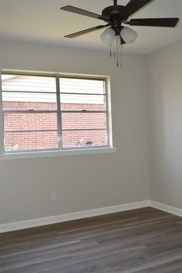 unfurnished room with a wealth of natural light, baseboards, and wood finished floors