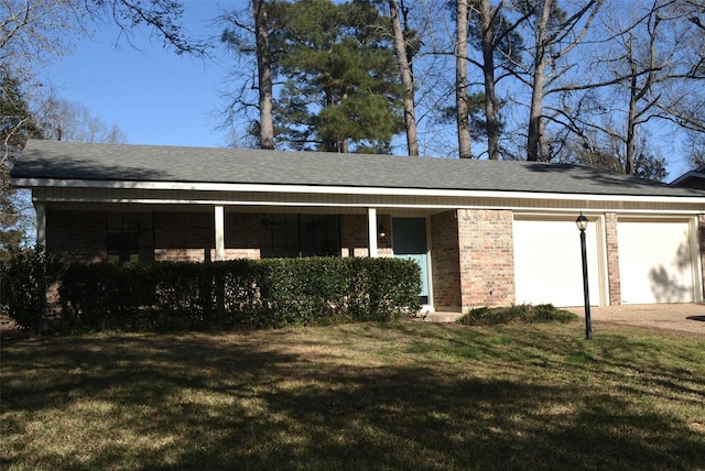 exterior space with a garage, a shingled roof, brick siding, dirt driveway, and a front lawn