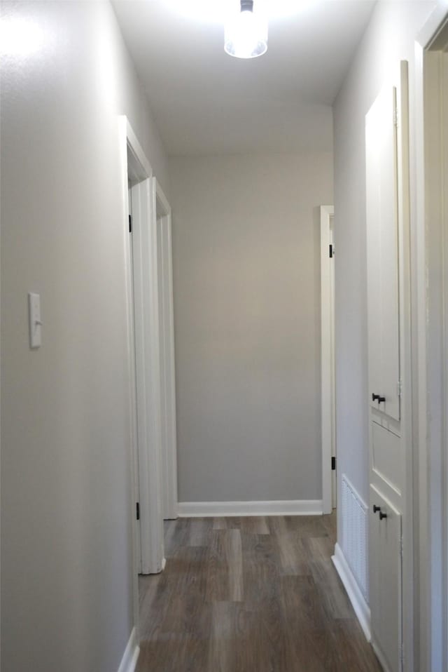 hall featuring baseboards and wood finished floors