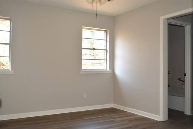 empty room featuring dark wood-style floors, ceiling fan, and baseboards