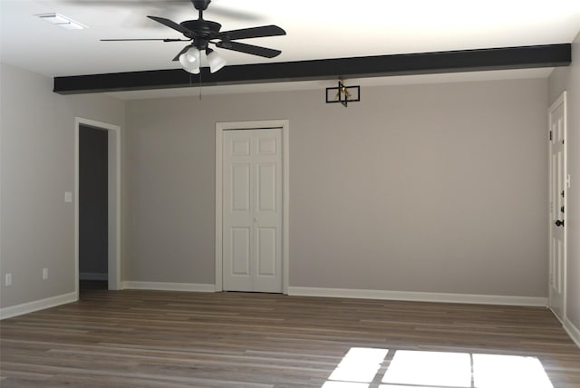 empty room featuring visible vents, baseboards, ceiling fan, wood finished floors, and beam ceiling